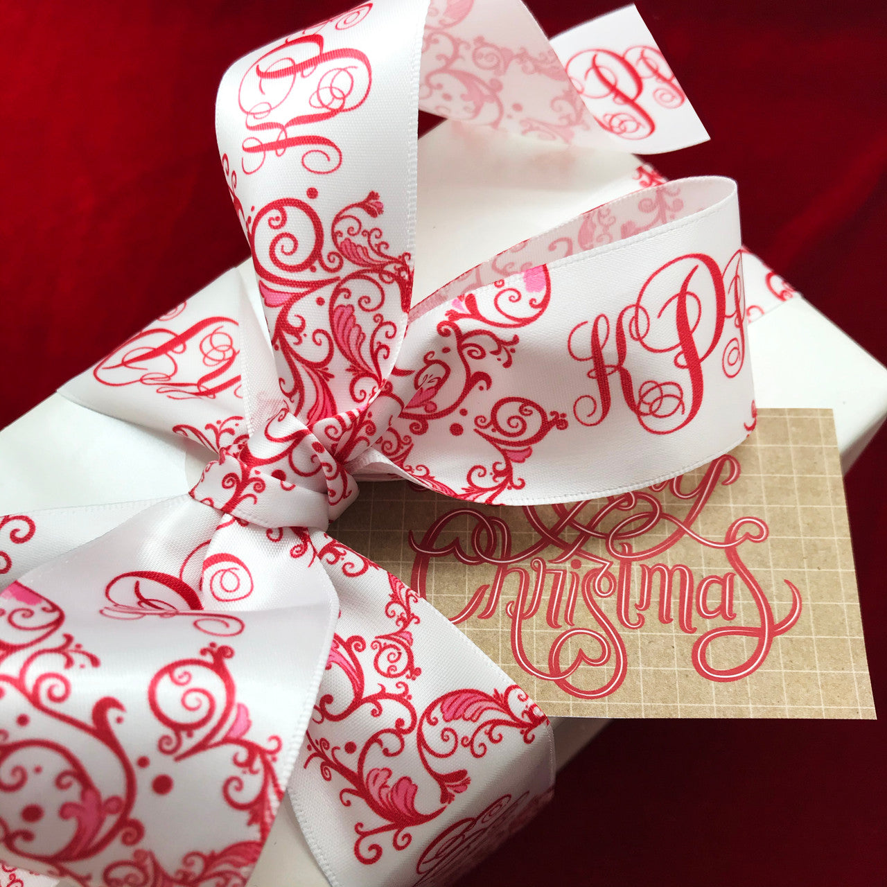 Red and white personalize monogram ribbon features a red custom designed Chinoiserie pattern with a beautiful matching font on 1.5"  white single face satin ribbon. This ribbon will add elegance and grace to every Christmas gift. Our ribbon is designed and printed in the USA