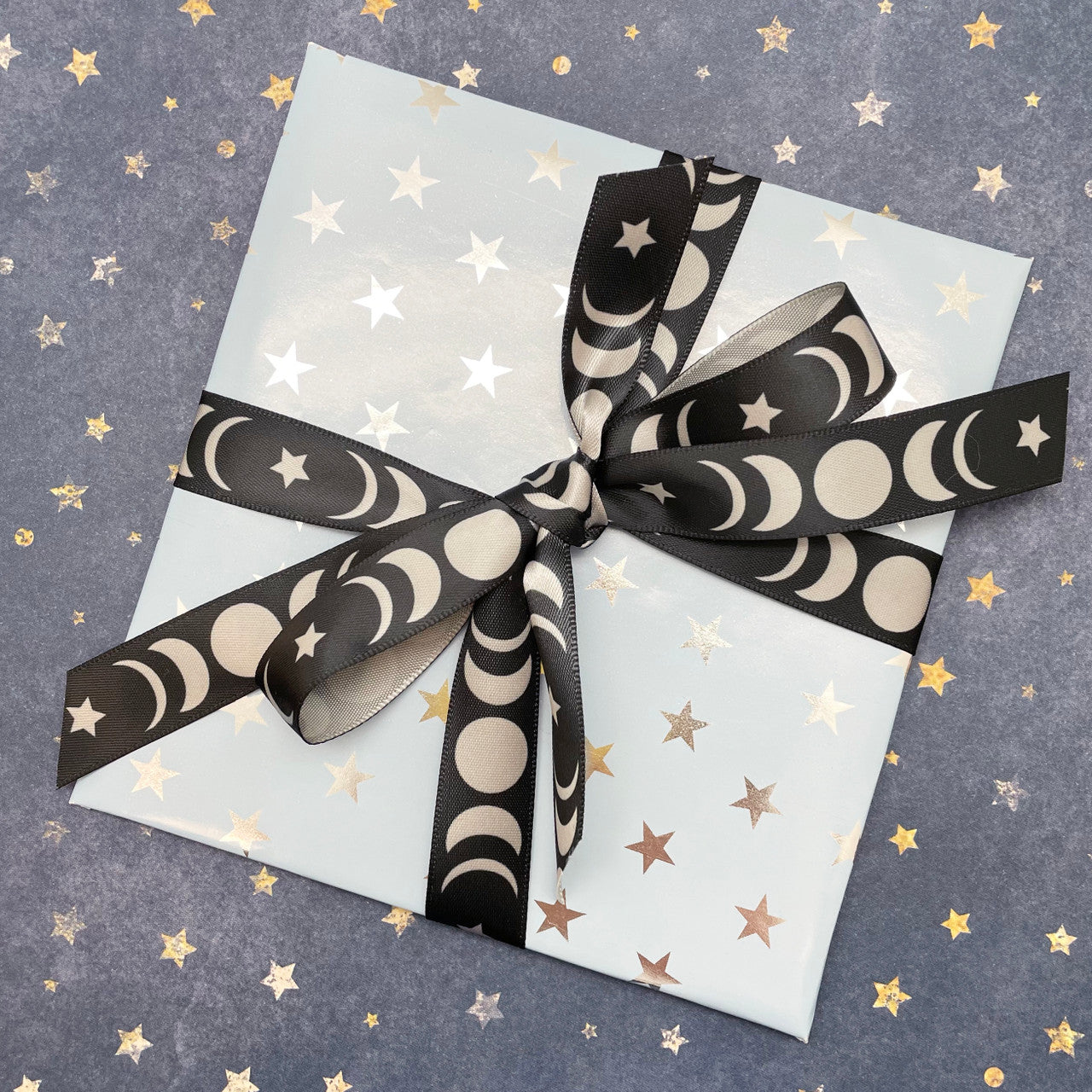Moon phase ribbon tied on a starry background for a pretty gift for any celestial  themed celebration!