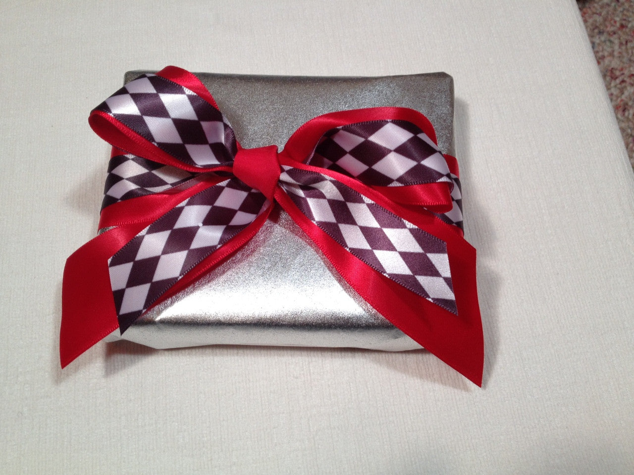 This simple little package is tied with red satin and our black and white harlequin looks so elegant tied in a bow!