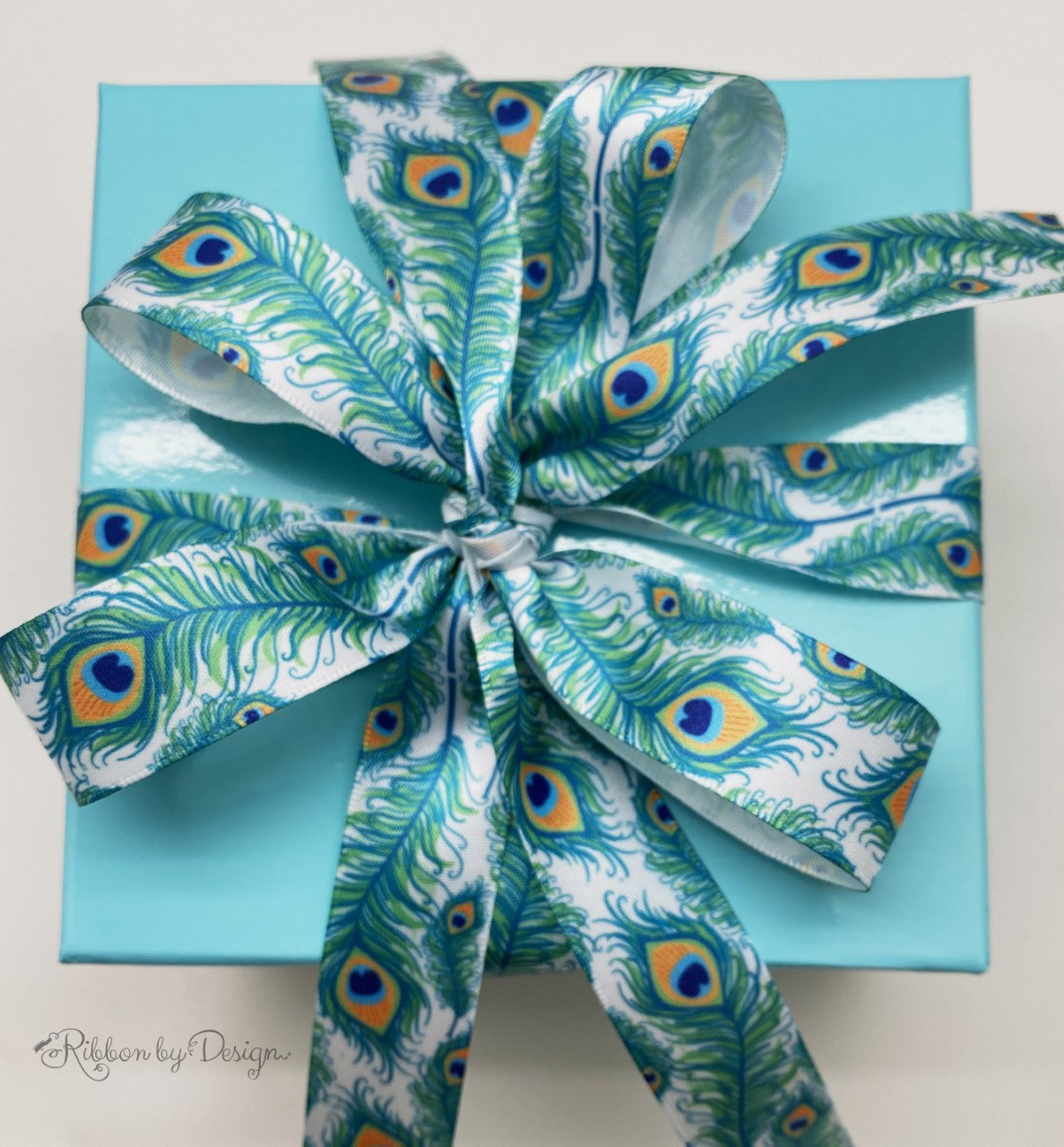 Peacock feathers ribbon in turquoise, green and yellow on 7/8" white single face satin