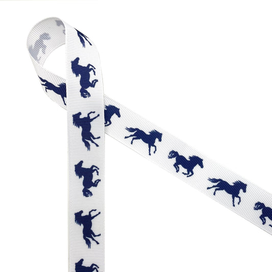Navy blue horses galloping along printed on a 7/8" white grosgrain ribbon are the ideal ribbon for equestrian themed hair bows, key fobs, party decor quilting and sewing projects! Be sure to have this ribbon on hand for horse shows and pony finals! Our ribbon is designed and printed in the USS