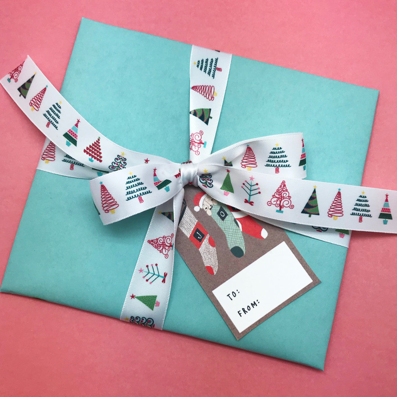 Make your presents extra special with this fun ribbon tied on non traditional colored paper for a fun twist on Christmas gift wrap!