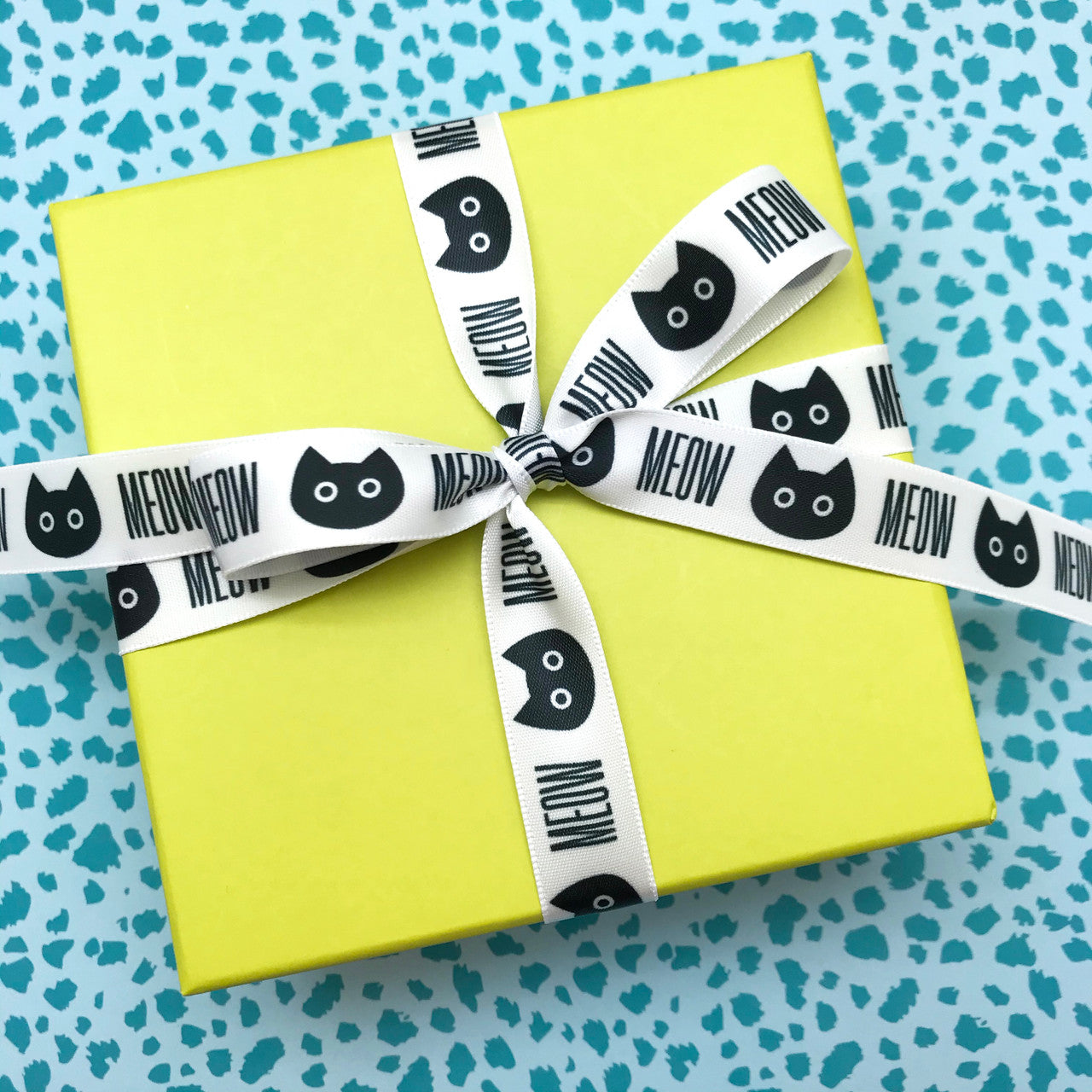 Cat heads in silhouette and MEOW in black printed on 5/8