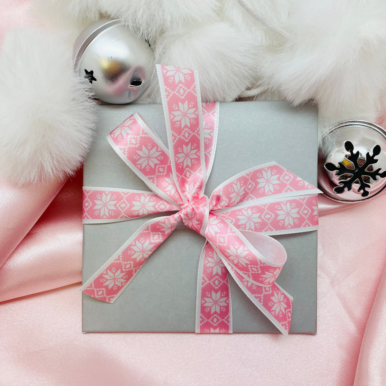 Nordic snowflakes in white on a pink background printed on 5/8" white single face satin ribbon tied on a sweet package makes for such a pretty pastel Holiday gift!