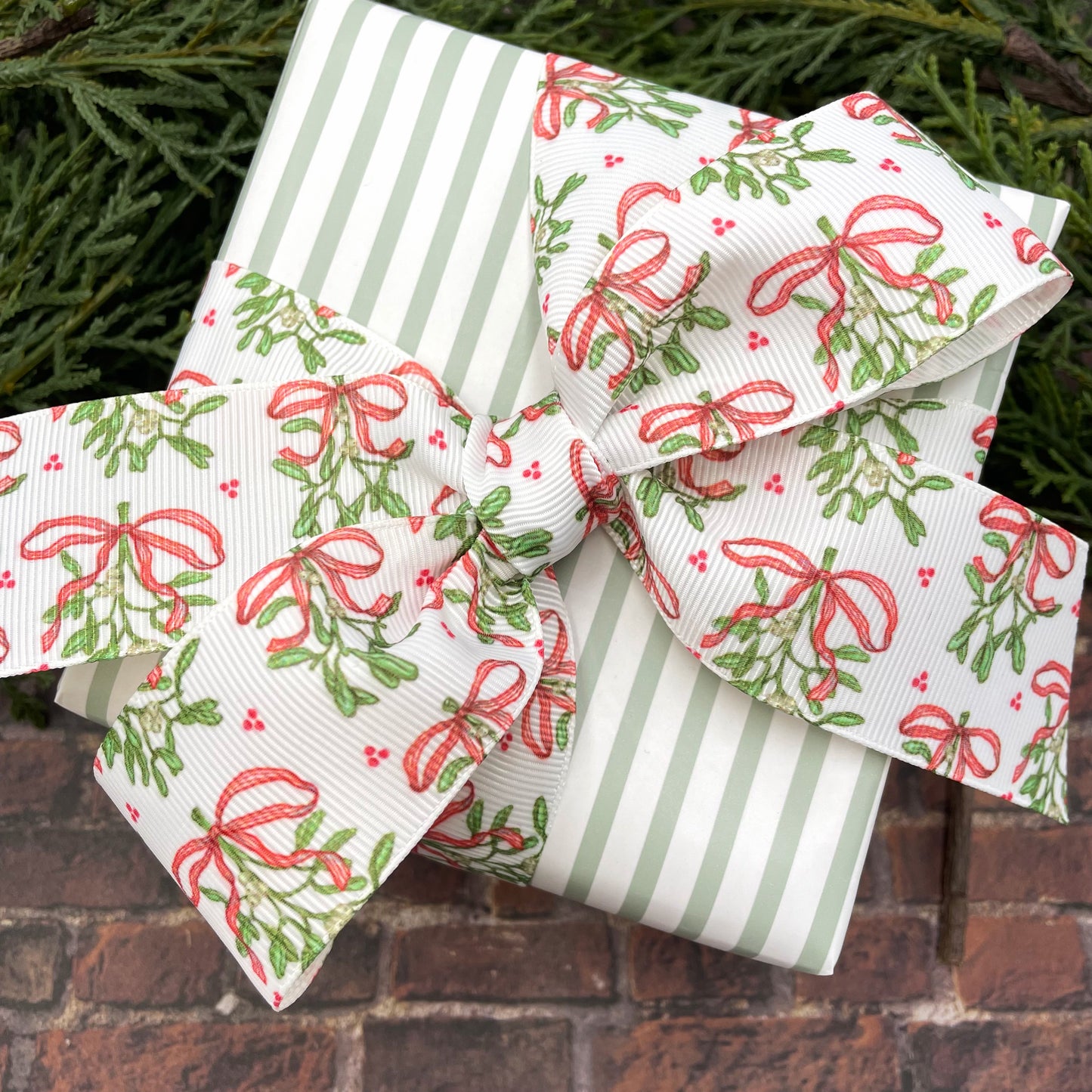 Holiday Mistletoe ribbon with delicate green mistletoe with white berries and red bows printed on 1.5" satin and grosgrain