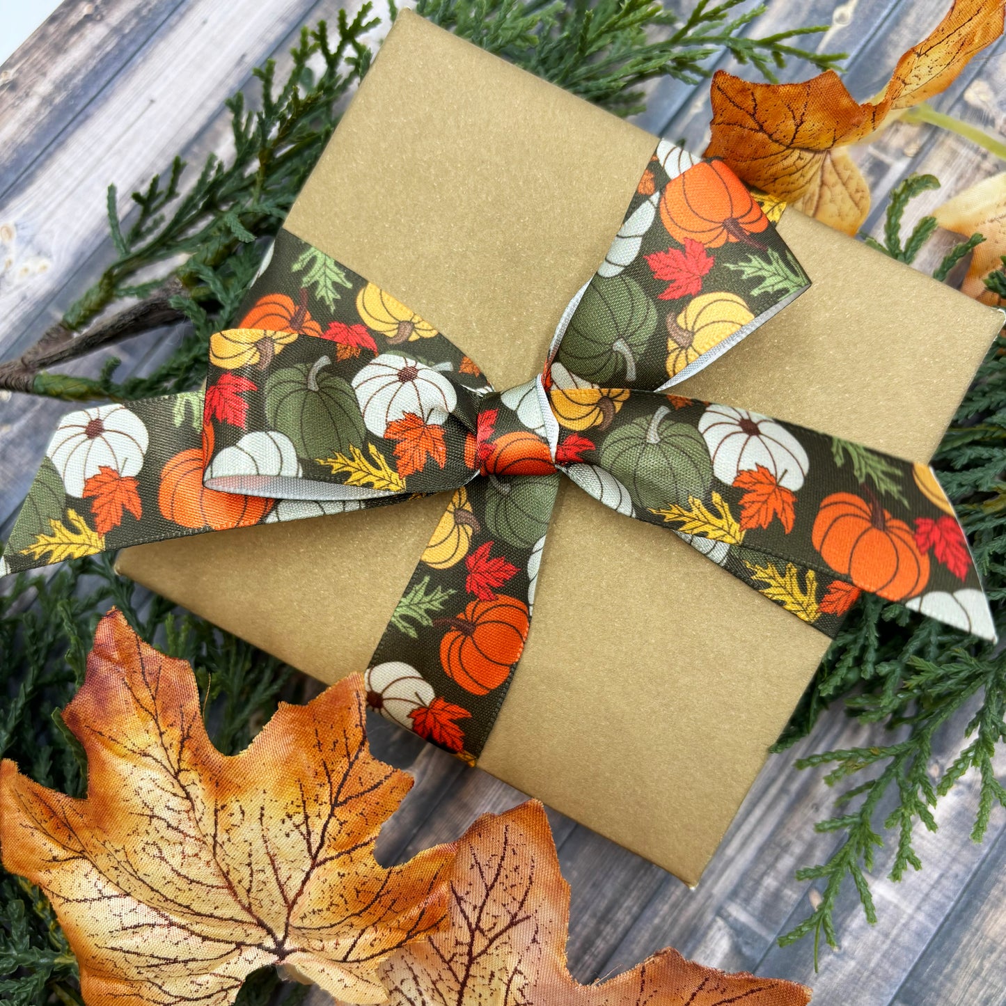 Fall Pumpkin Ribbon artful pumpkins in orange, green, yellow and white with Fall leaves on a dark green background printed on 7/8" and 1.5" white satin