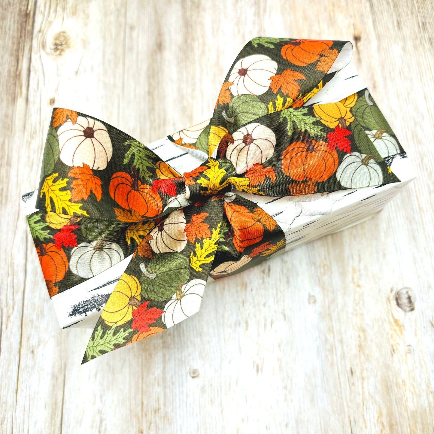 Fall Pumpkin Ribbon artful pumpkins in orange, green, yellow and white with Fall leaves on a dark green background printed on 7/8" and 1.5" white satin