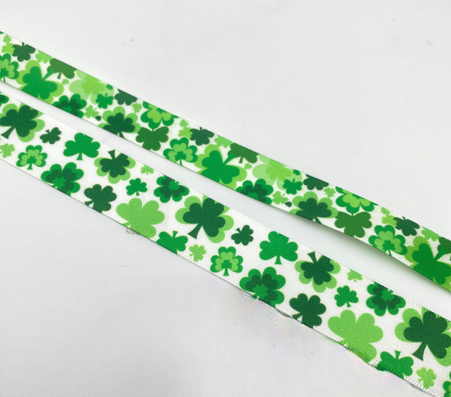 Shamrock ribbon shamrocks in all shades of green tossed on 5/8" and 7/8" white satin