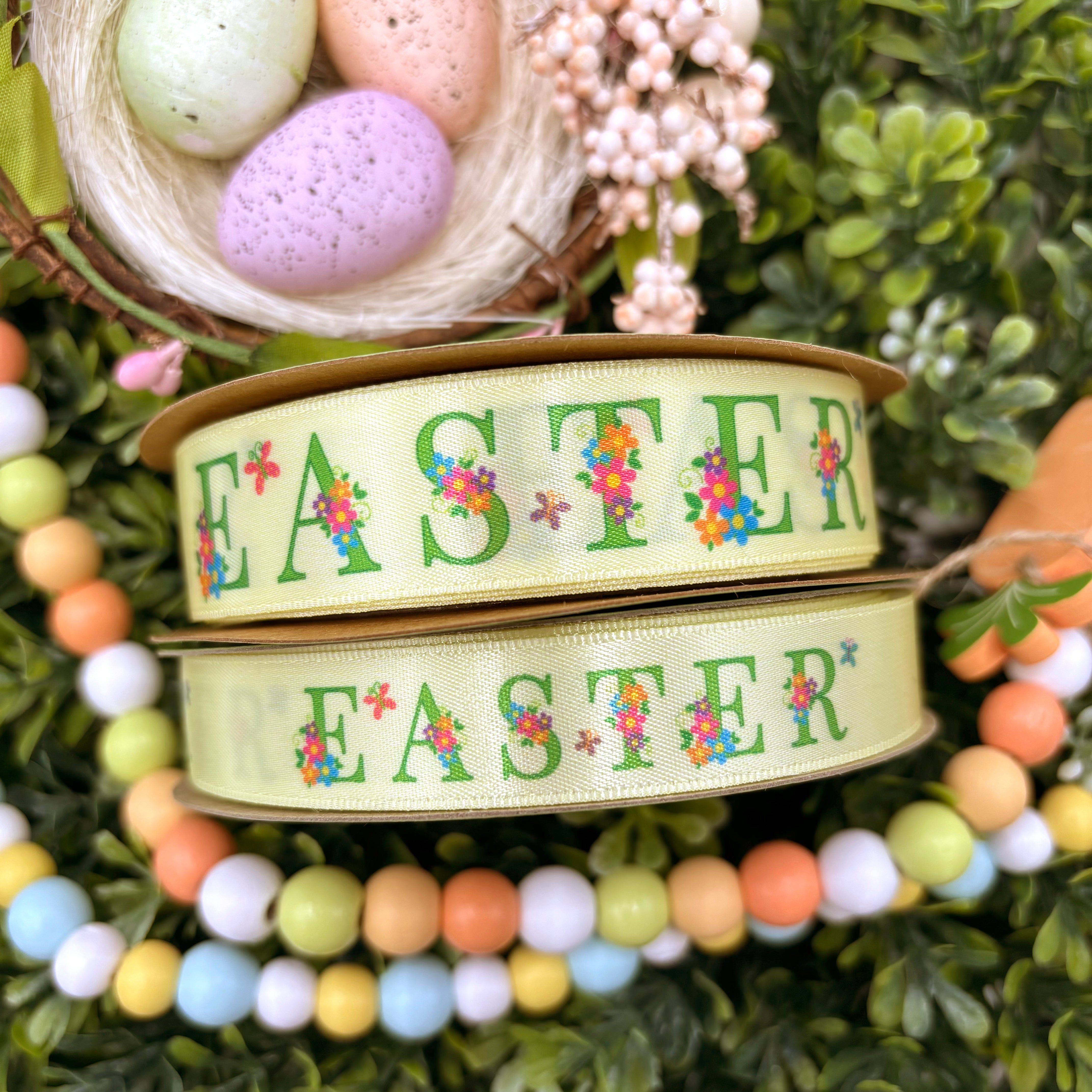 Easter ribbon Easter in green text decorated with Spring flowers on a