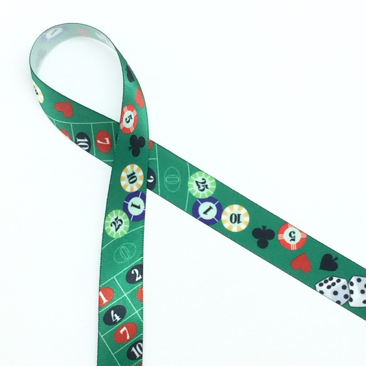 Casino ribbon in 5/8" width featuring tossed spades, diamonds, hearts and clubs along with dice and chips.