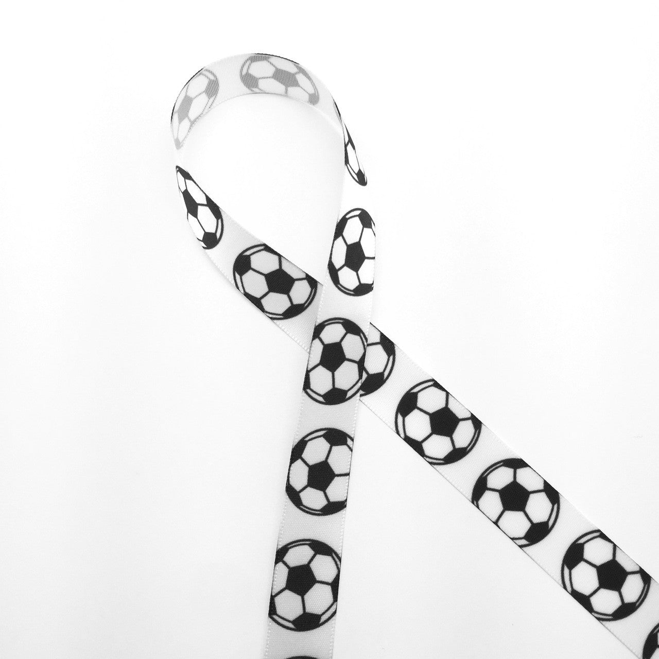 Soccer balls lined up along our 5/8" white single face satin ribbon. The ideal addition to a soccer themed party!