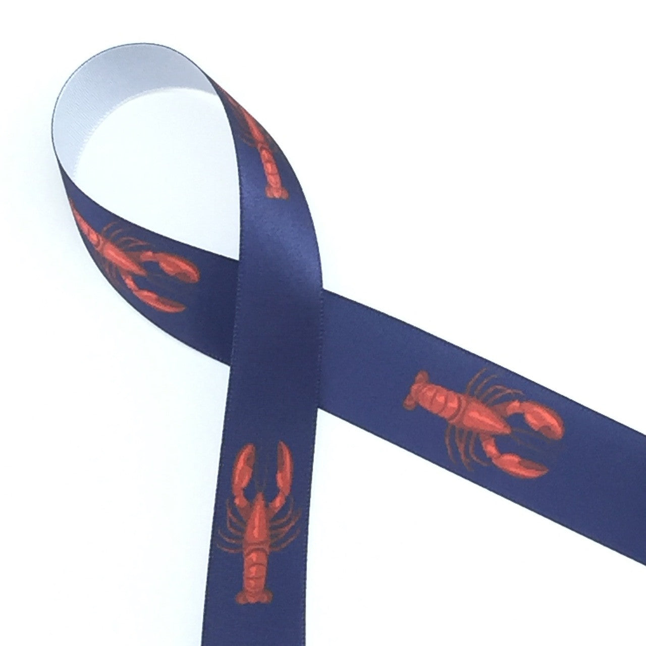 Red lobsters on a navy background are printed on white single face satin ribbon. Ideal for any nautical themed party!