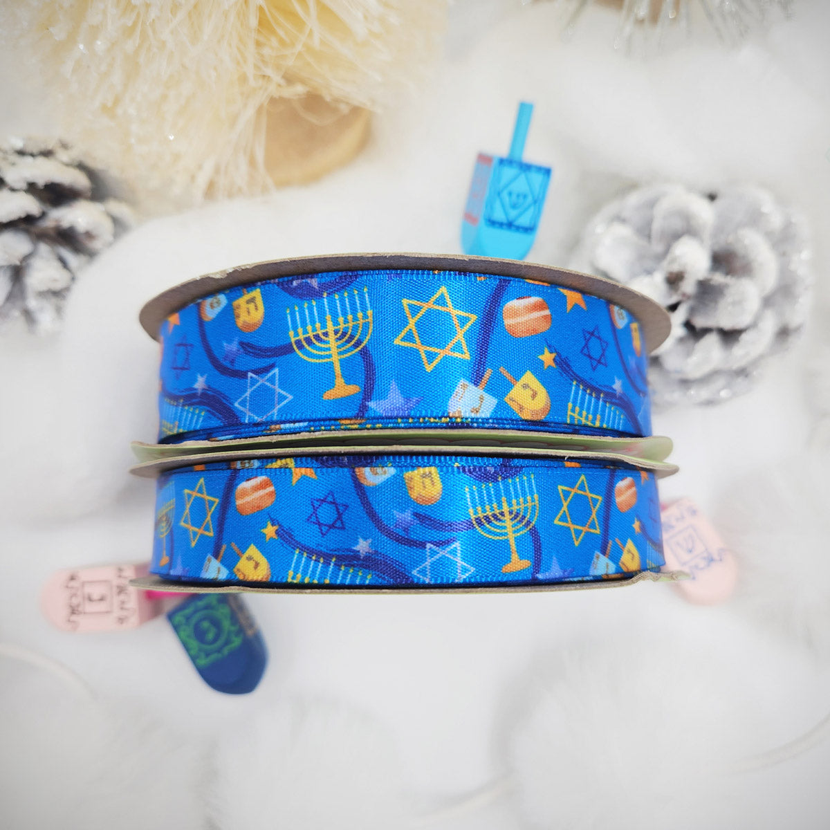 Hanukkah Ribbon in shades of dark blue with Menorahs, dreidels and Star of David tossed for decor printed on 5/8" and 7/8" white satin