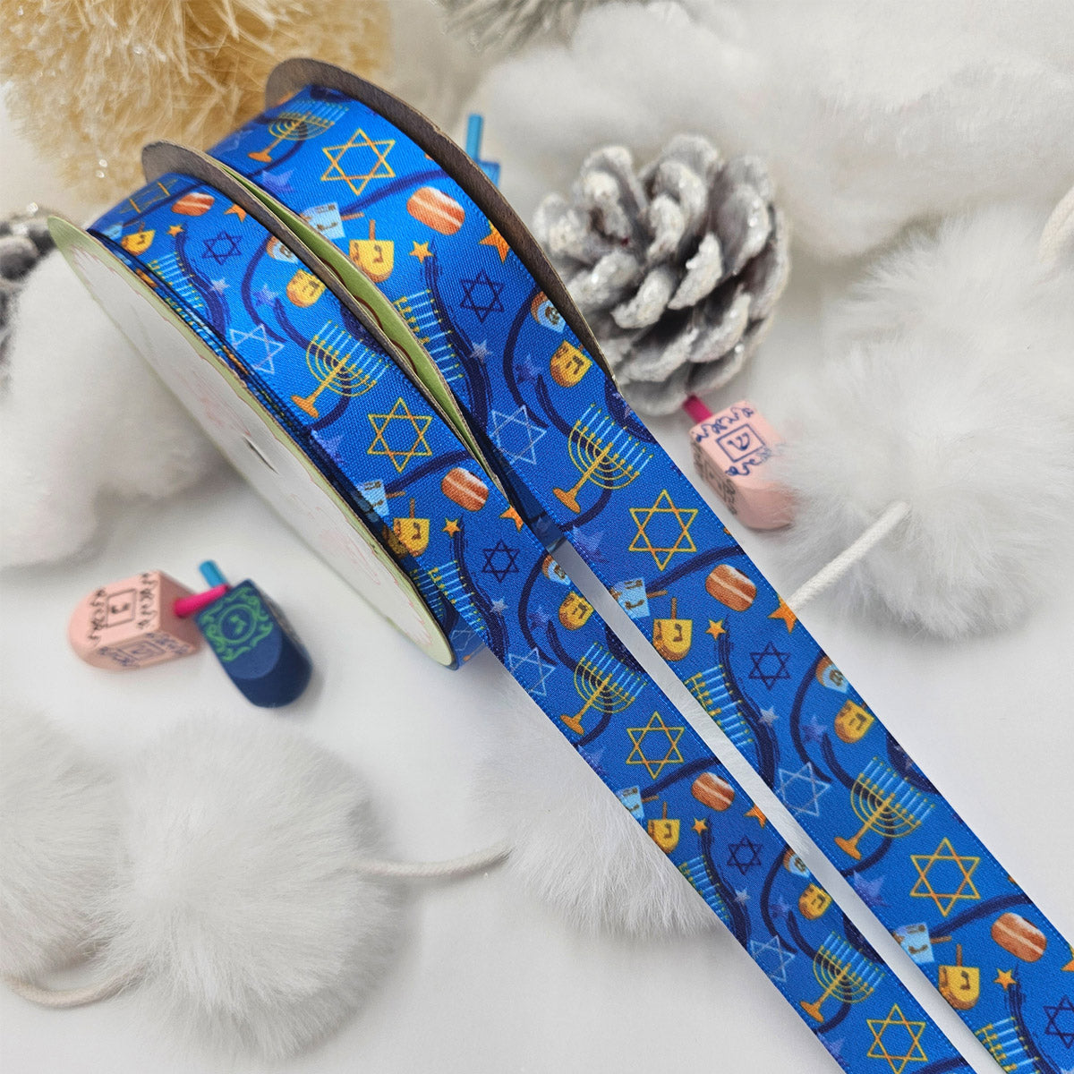 Hanukkah Ribbon in shades of dark blue with Menorahs, dreidels and Star of David tossed for decor printed on 5/8" and 7/8" white satin
