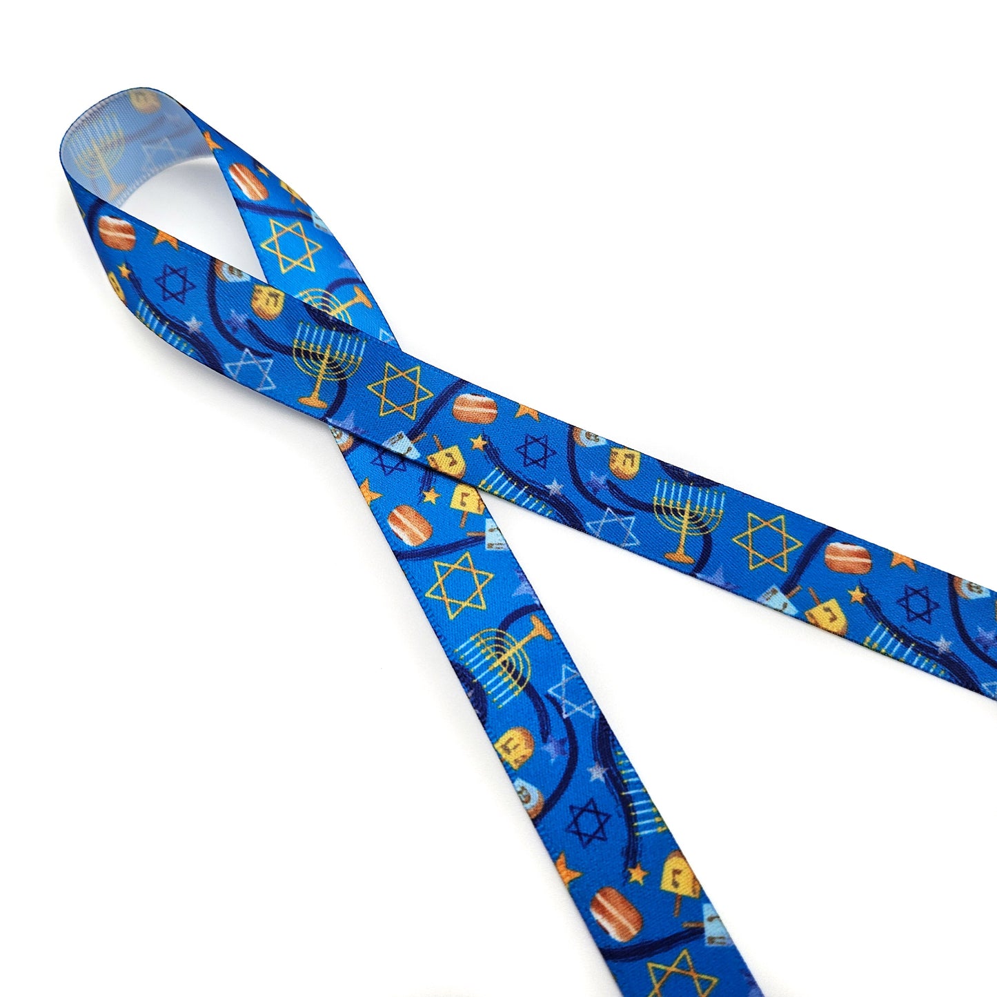 Hanukkah Ribbon in shades of dark blue with Menorahs, dreidels and Star of David tossed for decor printed on 5/8" and 7/8" white satin