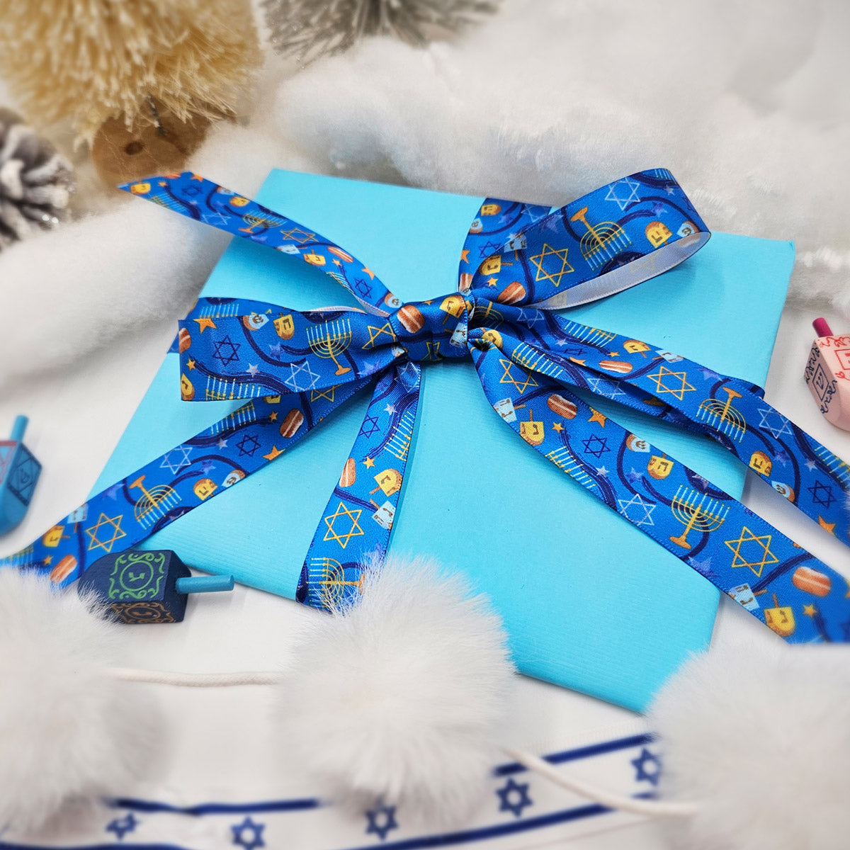 Hanukkah Ribbon in shades of dark blue with Menorahs, dreidels and Star of David tossed for decor printed on 5/8" and 7/8" white satin