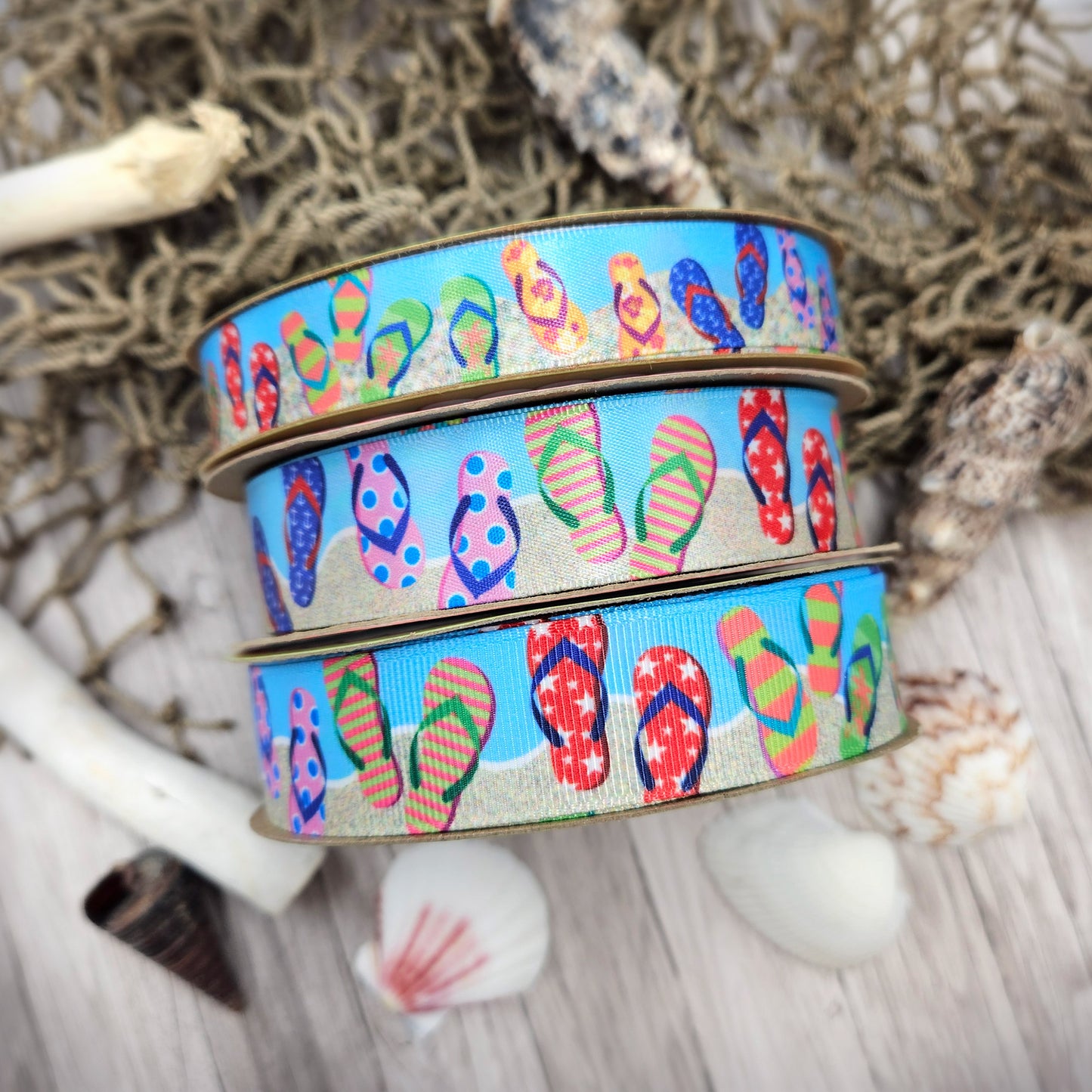 Flip Flop ribbon colorful flip flops in stripes, stars, and floral designs on a sand and blue background printed on  5/8" and 7/8" white single face satin and grosgrain
