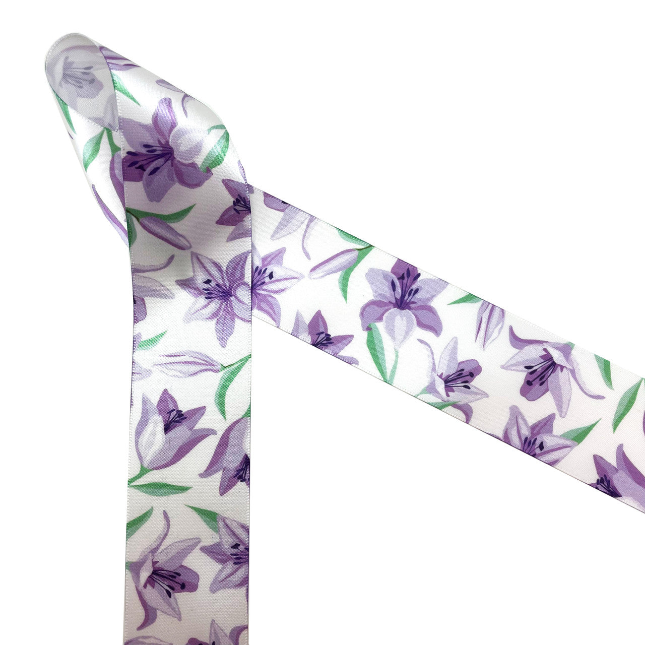 Lavender Lillies with green leaves and stems printed on 1.5" white single face satin is the ideal ribbon for Spring, Easter and Mother's day. Florals are trending making this a perfect ribbon for bridal showers and wedding decor too. This is a great ribbon for gift wrap, gift baskets, table decor, quilting, sewing and wreath making projects too. All our ribbon is designed and printed in the USA