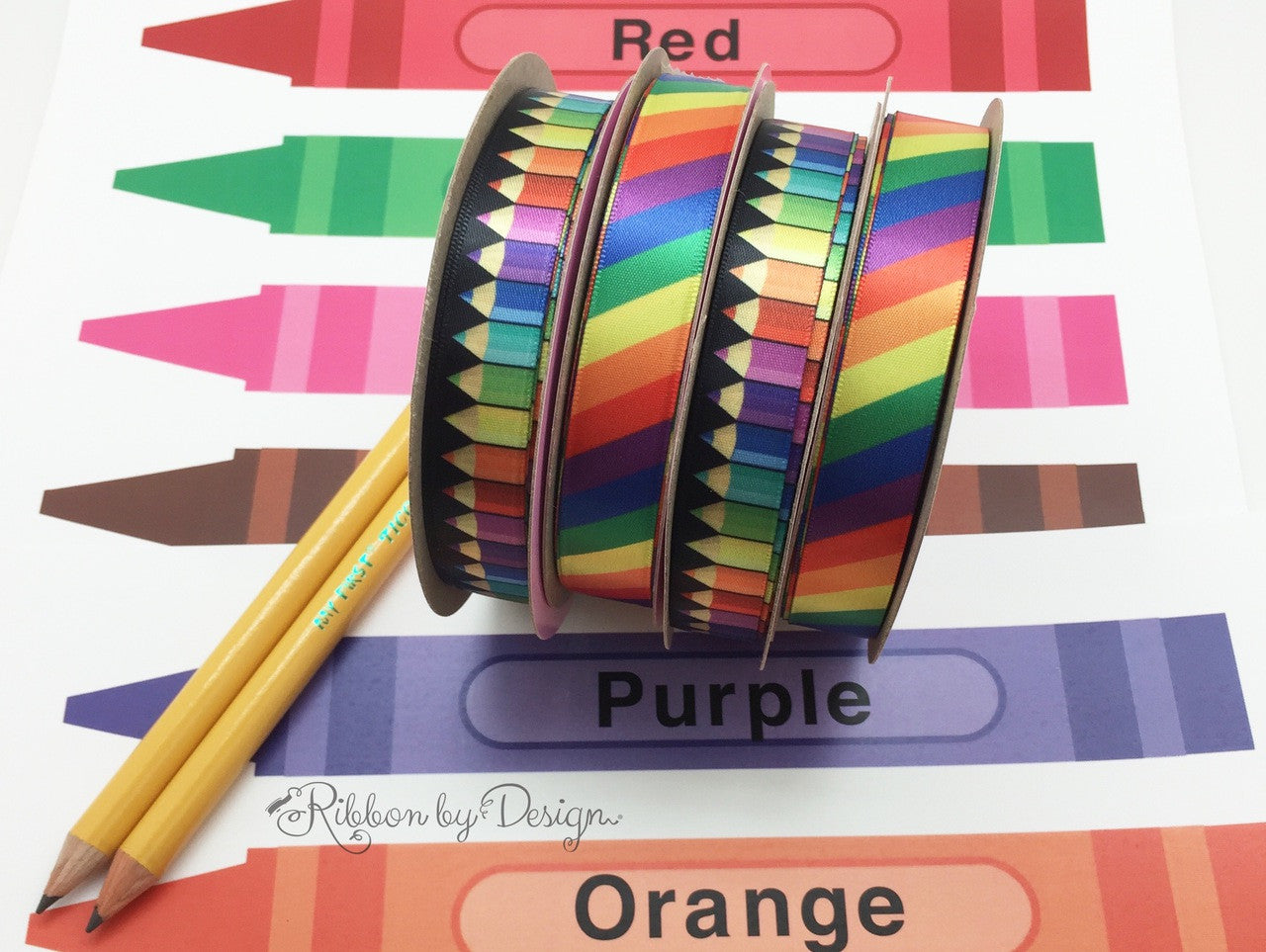 Colored pencils and rainbow ribbon make all the primary colors sing! Designed and printed in the USA