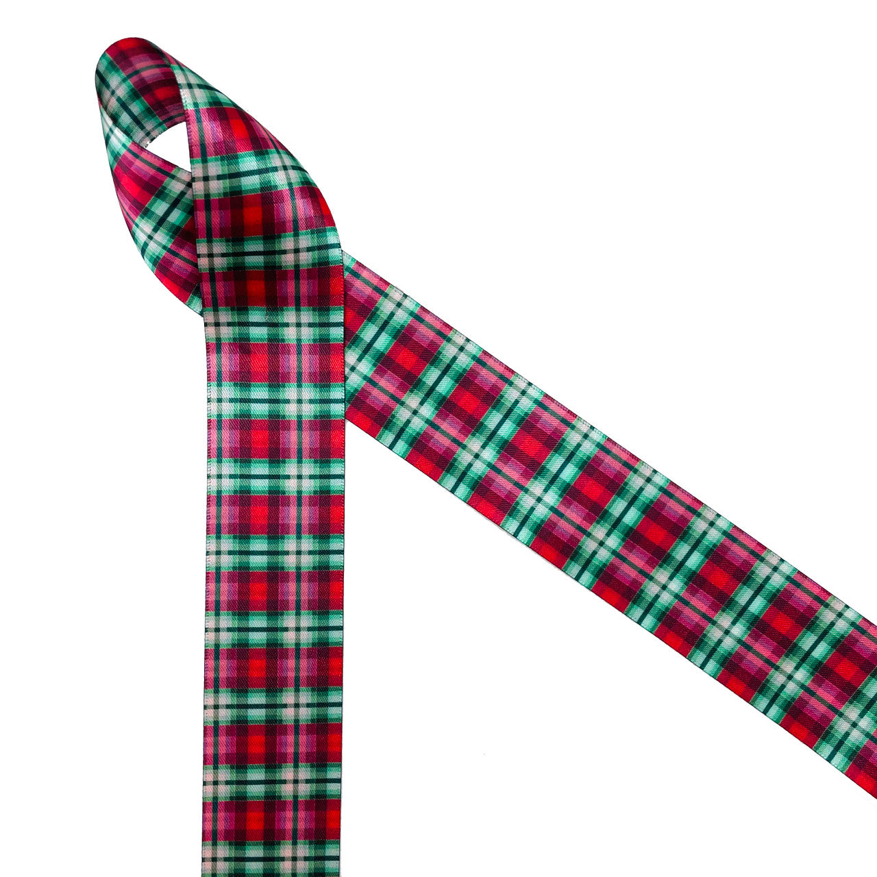 Christmas plaid in red and green is a Holiday classic design. Christmas plaid in red and green printed on 1.5" white double face satin ribbon is  the perfect addition to any Holiday decor. Use this beautiful ribbon for gift wrap, gift baskets, holiday decor, tree trimming, floral design, wreaths, craft ribbon, sewing and quilting projects. All our ribbon is designed and printed in the USA