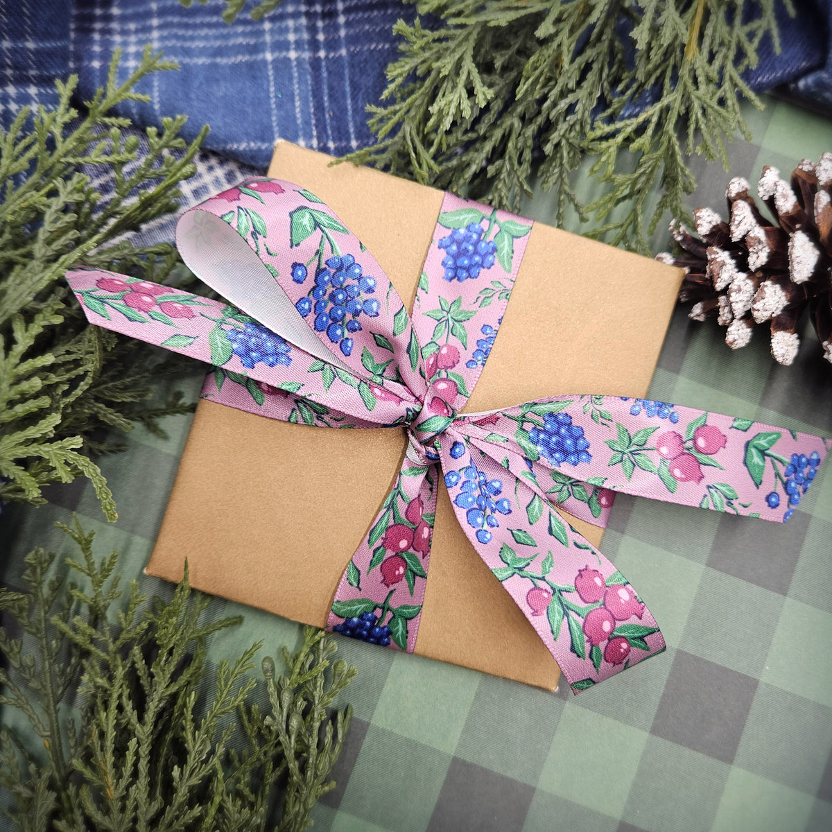 Winter berries ribbon berries in blue, green and deep pink on a mauve background offered in 5/8", 7/8" and 1.5" widths