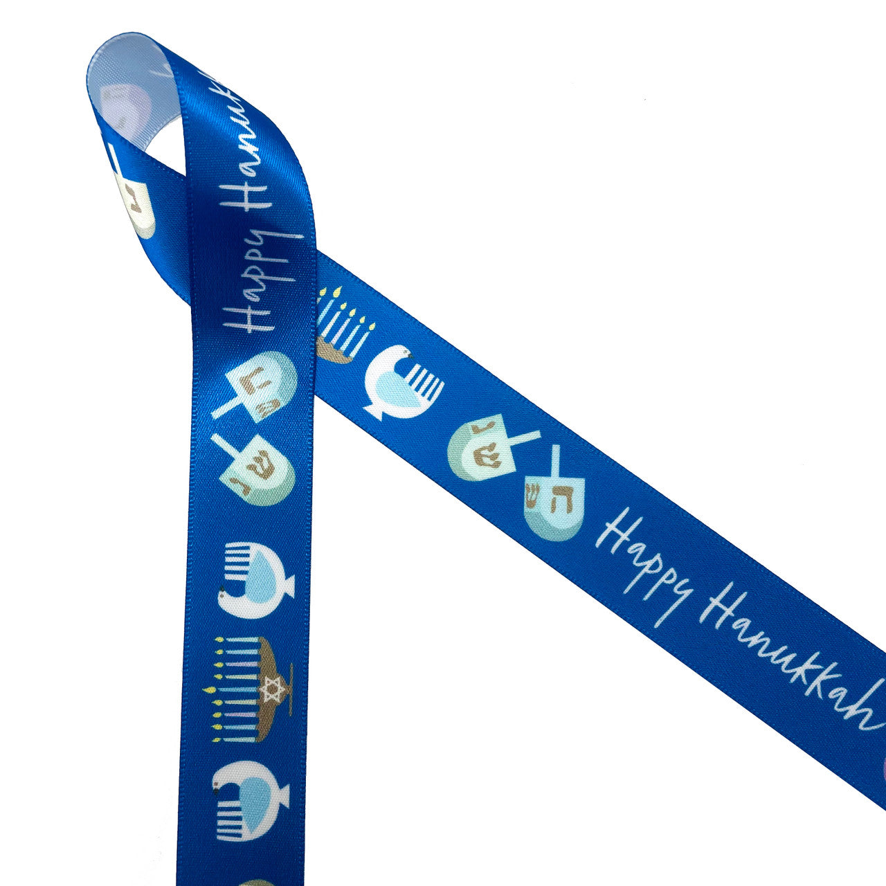 Hanukkah ribbon Happy Hanukkah in white with dreidels and menorahs on a blue background printed on 7/8" white single face satin. This fun ribbon is perfect for gift wrap, gift baskets, party decor, table decor, sewing, quilting and craft projects. Be sure to have this ribbon on hand for all eight nights of celebration. All our ribbon is designed and printed in the USA