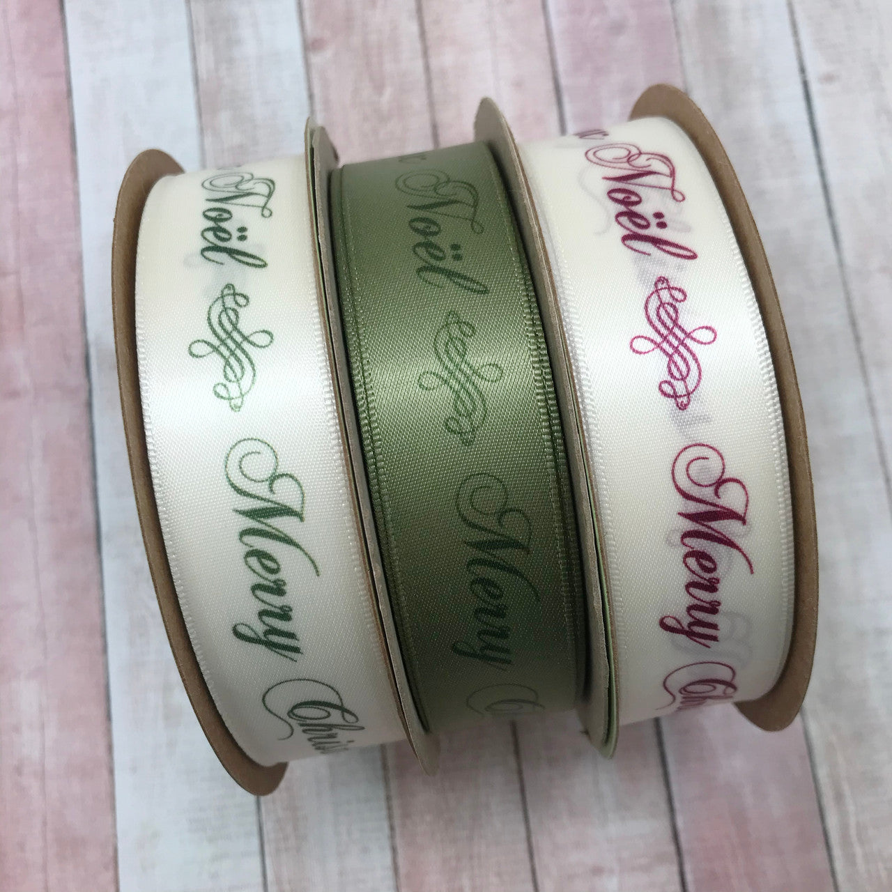Joyeux Noel and Merry Christmas in green on sage printed on sage and antique white pair beautifully with the same design with ruby lettering. These ribbon are perfect for those who wish to express their holiday joy in French and English. Use this luxury ribbon for gift wrap, tree trimming, wreaths, floral design and table decor. All our ribbon is designed and printed in the USA