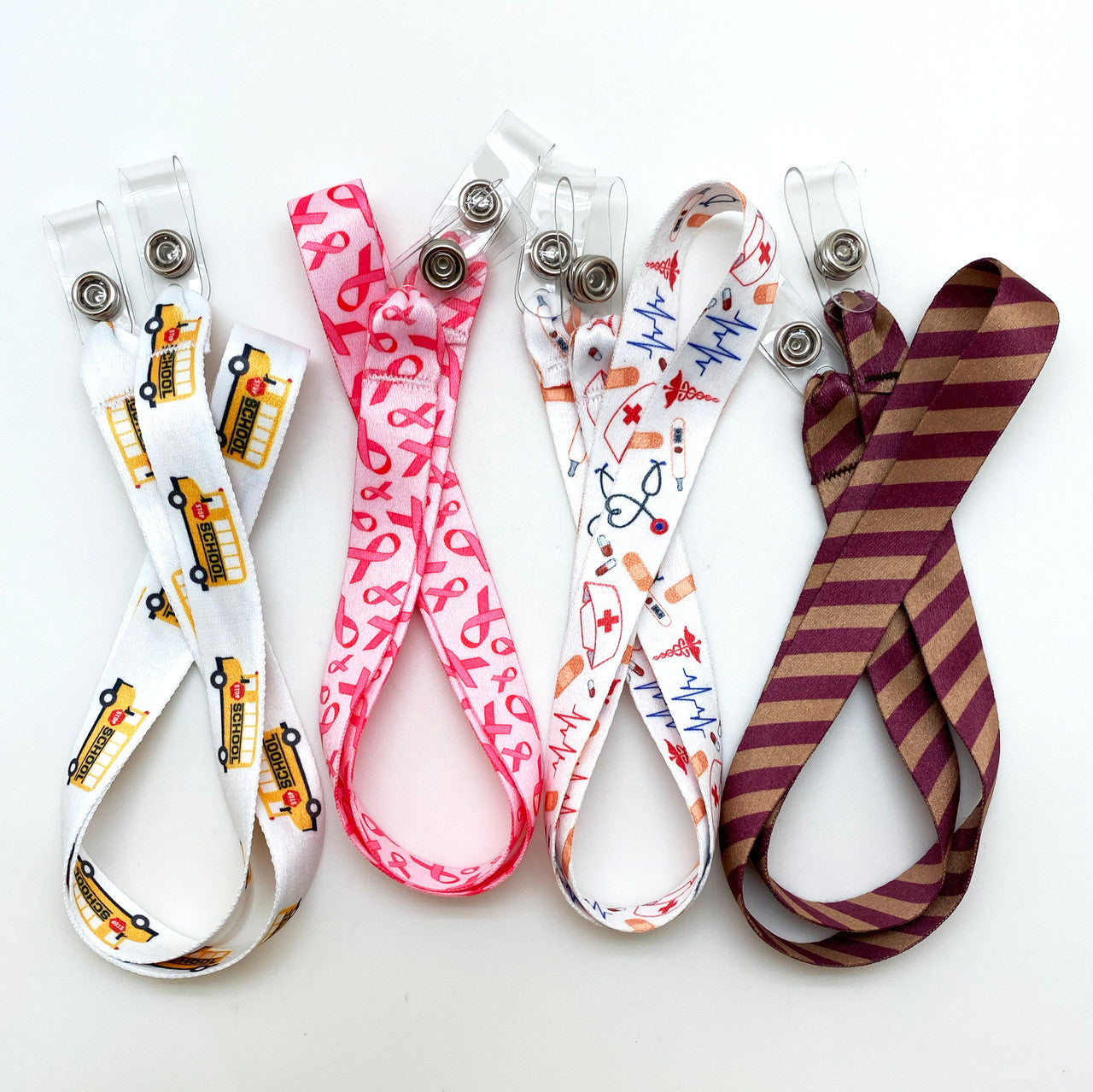 These lanyards are available in four designs for anyone! Choose among breast cancer awareness, medical theme,  school buses and Wizard  stripes of burgundy and gold.  Never lose a face mask at school, sports practice, on the bus or during lunch again!