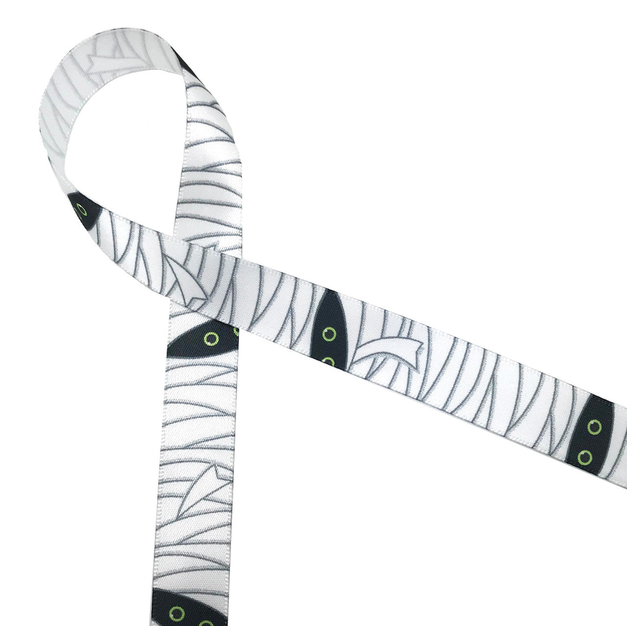 Mummy themed ribbon on 5/8" white single face satin  with lots of white wrapping and two green eyes peering out from the dark is a fun addition to any Halloween party!